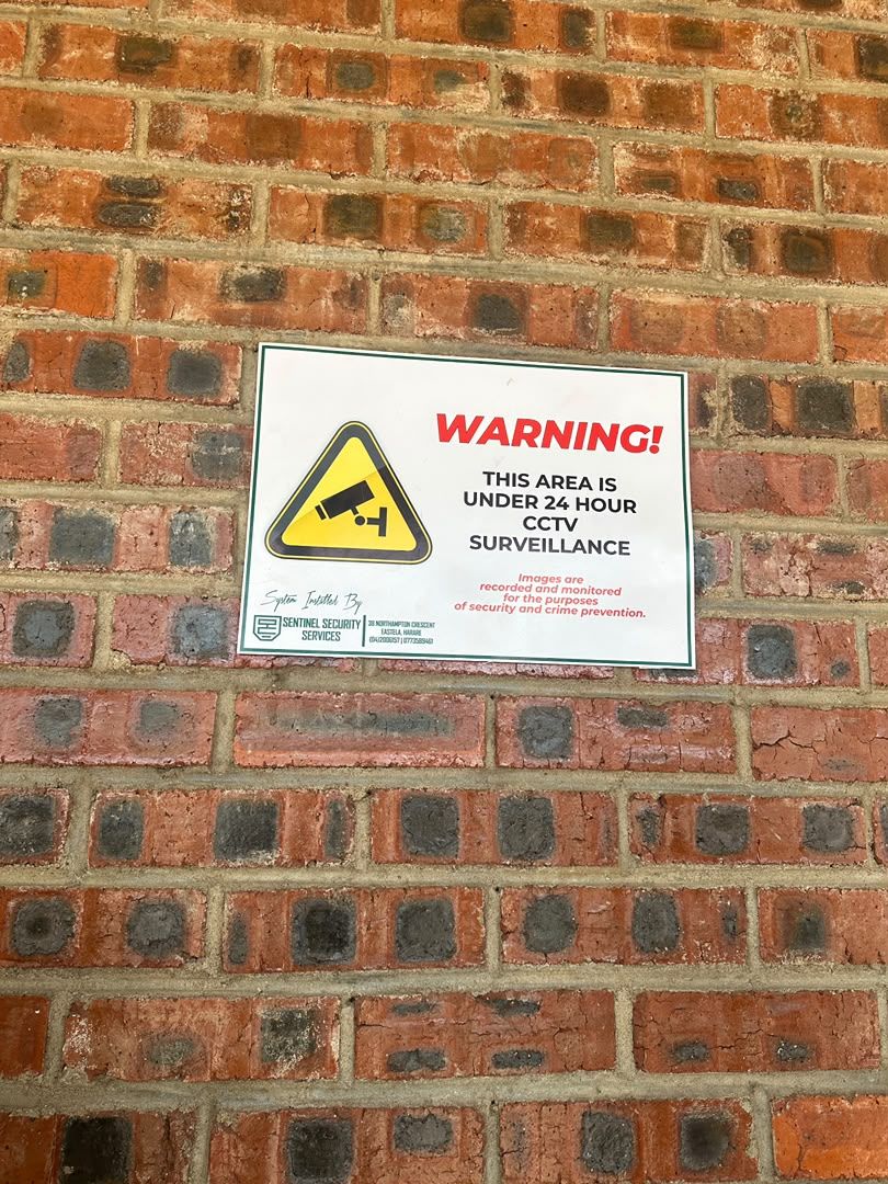 A Sentinel CCTV warning sign fixed to a brick wall