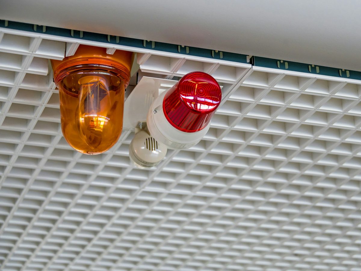 A fire sounder and call point on a ceiling